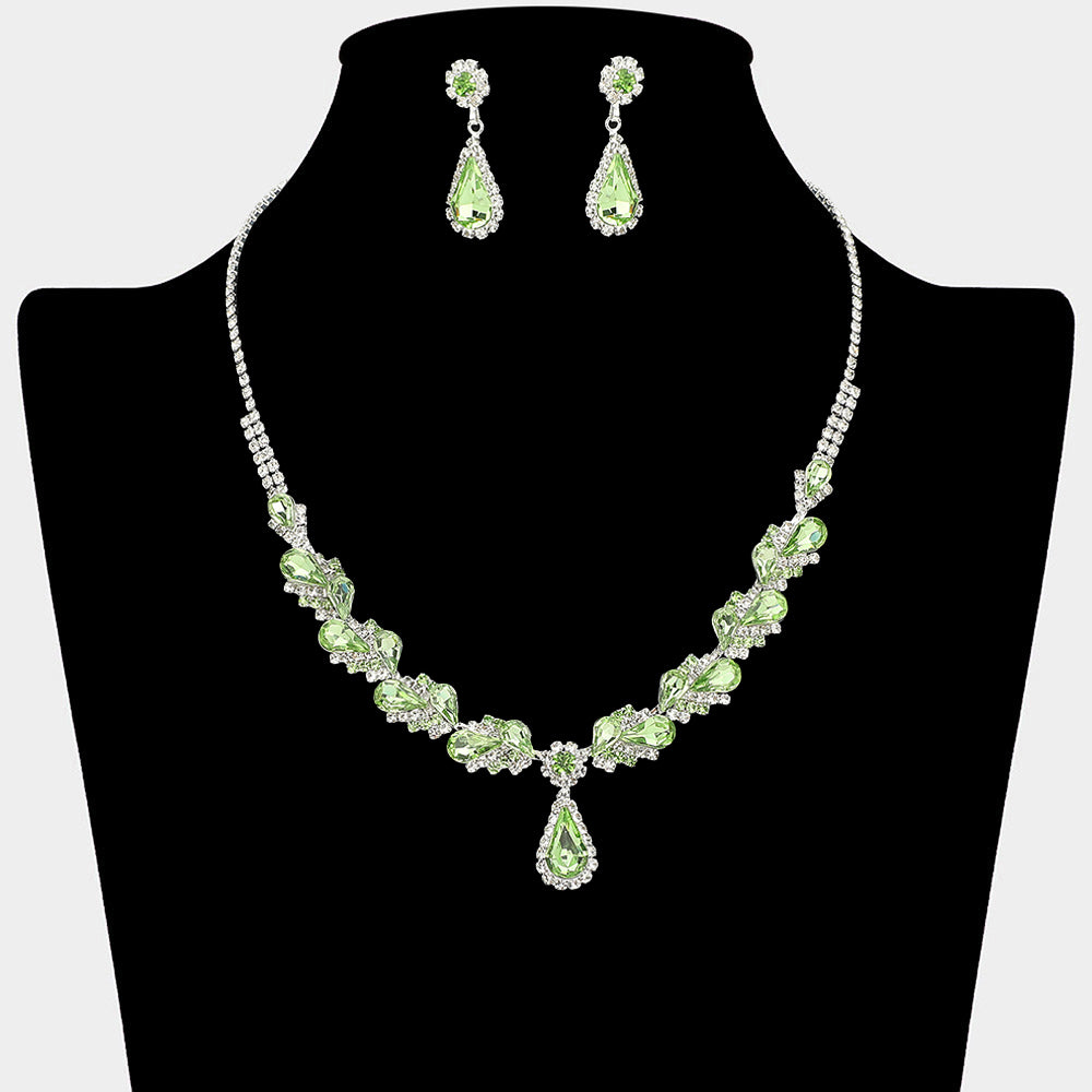 Light green marquise pendant necklace set on silver with matching earrings for prom and evening wear on a black mannequin bust on a white background.
