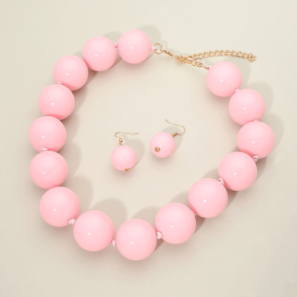 Light Pink chunky ball beaded statement necklace set with oversized round beads, matching drop earrings, displayed on a light cream background.