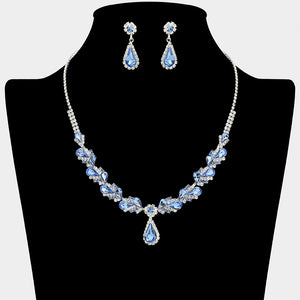 Light sapphire marquise pendant necklace set on silver with matching earrings for prom and evening wear on a black mannequin bust on a white background.