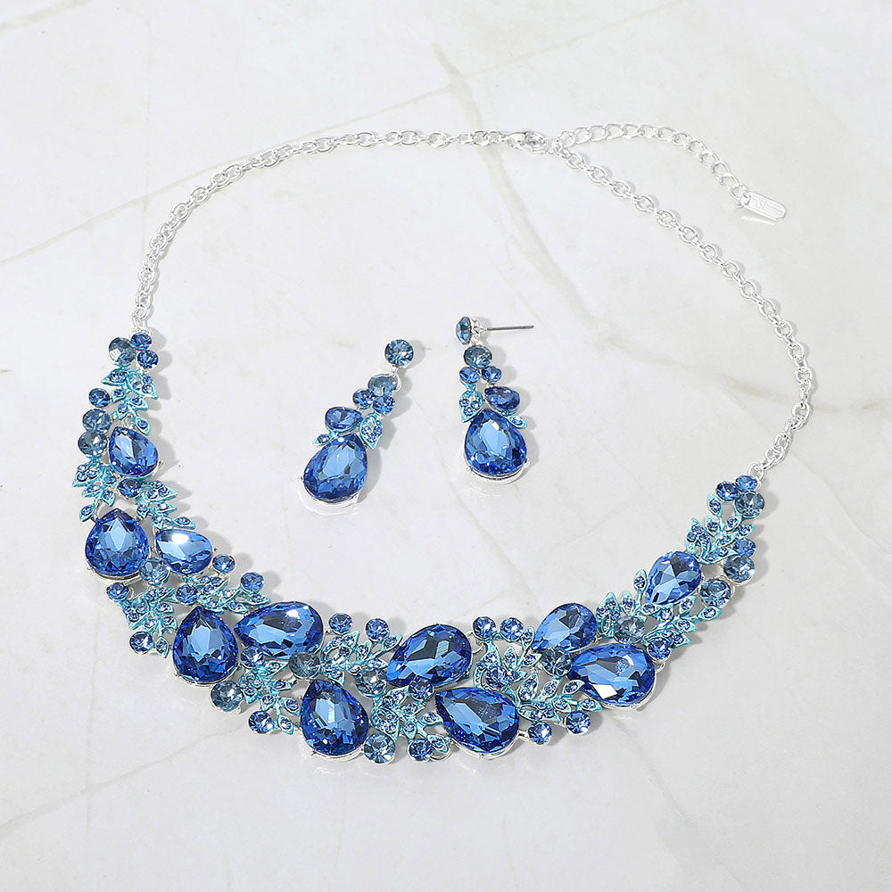 Light sapphire blue teardrop leaf branch statement necklace set on silver on a white marble background