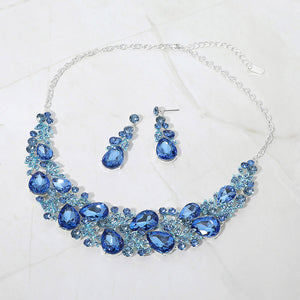 Light sapphire blue teardrop leaf branch statement necklace set on silver on a white marble background