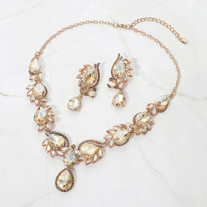 Champagne Gold Stone teardrop formal necklace and matching earrings set on gold displayed on a white background.