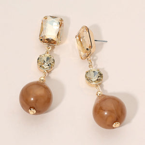 Champagne Gold Stone faceted crystal and ball drop statement earrings on gold with rectangular, round, and spherical champagne stones, displayed on a light beige background.