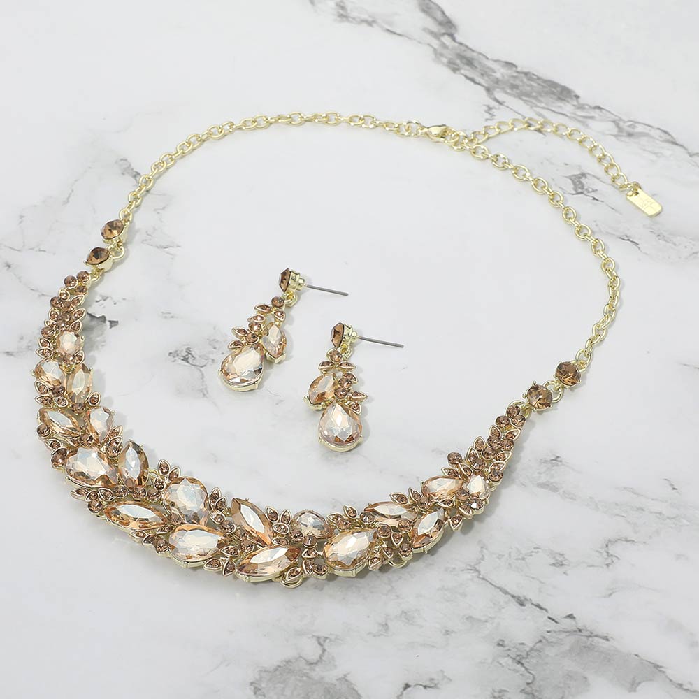 Light topaz gold stone marquise crystal cluster necklace set on gold with matching earrings, elegant statement jewelry for prom and evening wear on a marble background