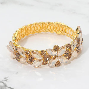 Light topaz - gold stone marquise floral crystal bracelet on gold with adjustable fit, elegant statement jewelry for prom and evening wear on a marble background