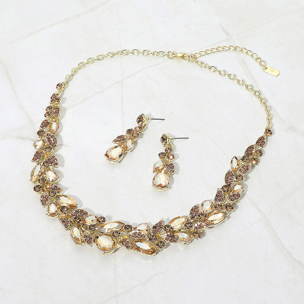 Light Topaz-Gold Stone marquise and teardrop crystal cluster formal necklace set on gold with matching earrings on white marble background