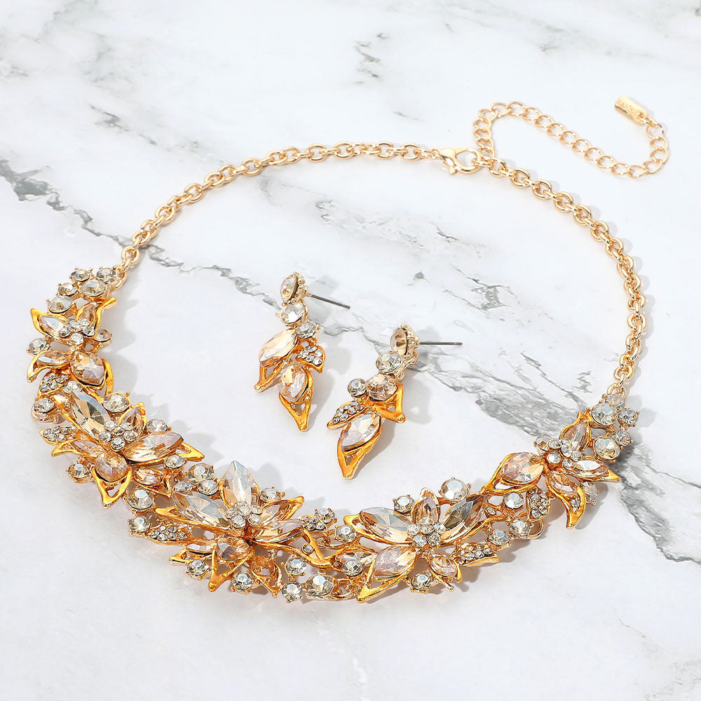 Light topaz gold stone collar-bib necklace set with matching earrings for homecoming, pageants, or evening wear on a grey and white granite background