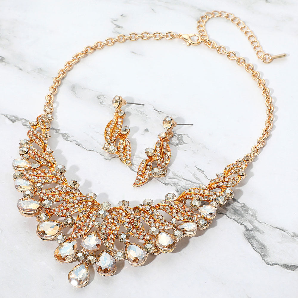 Light topaz gold stone teardrop leaf crystal collar necklace set on gold with matching earrings, elegant statement jewelry for prom and evening wear on a marble background