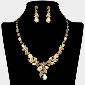 Light topaz teardrop leaf necklace set on gold with matching earrings for prom and evening wear on a black mannequin bust on a white background.