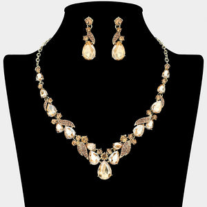 Light topaz gold stone teardrop leaf prom necklace set on gold with matching earrings displayed on a black mannequin bust on a white background.