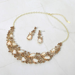 Gold stone light topaz teardrop leaf branch statement necklace set on gold on a white marble background