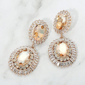 Champagne Gold Stone vintage double oval crystal statement earrings in a gold finish featuring two oval champagne stones surrounded by sparkling crystal halos, displayed on a white marble background.
