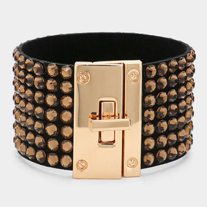 Light topaz gold stone on black 7-row rhinestone bling studded bracelet with gold hardware on a white background