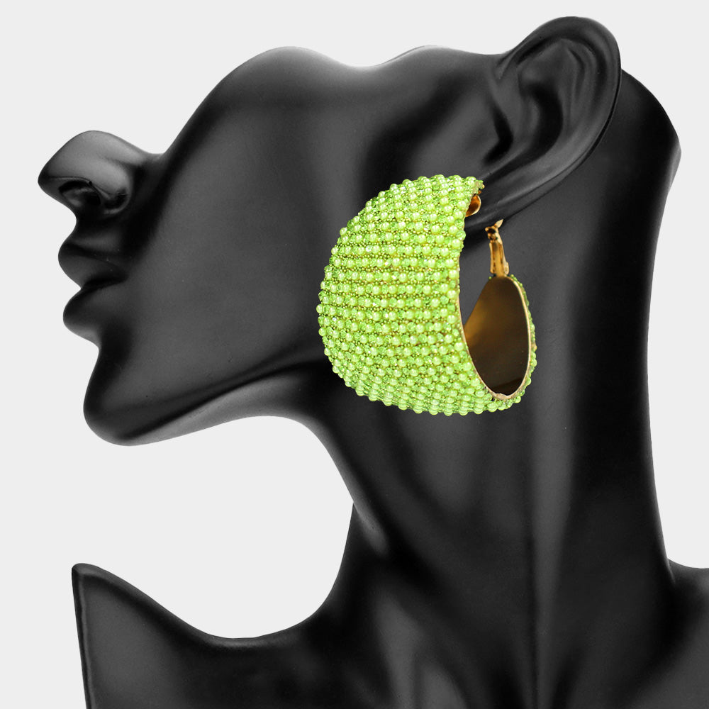 Lime green bling pavé crystal wide hoop earrings on gold-tone metal with dense faceted rhinestone coverage and omega backs, displayed on a black mannequin profile.