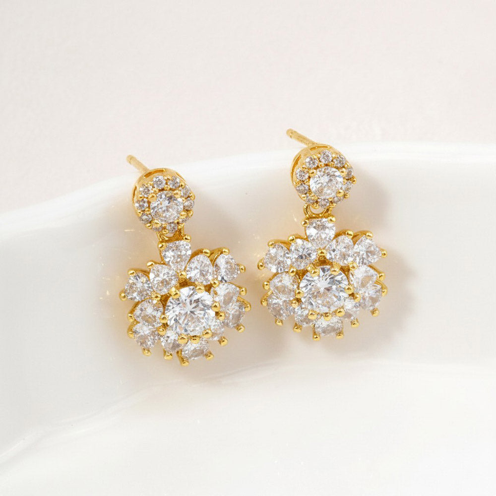Little girls clear crystal drop earrings in a gold finish featuring round crystal studs and floral-inspired crystal clusters, displayed on a white jewelry stand.