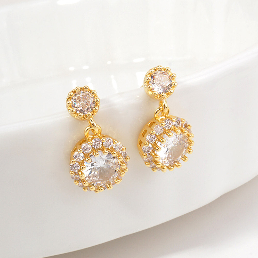Little girls clear crystal halo drop earrings on gold with round crystal halos, displayed on a white jewelry stand.