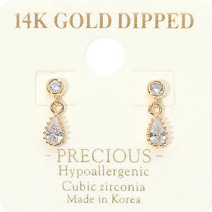 A pair of gold dangle earrings backed in gold with clear teardrop-shaped cubic zirconia stones, displayed on a cream-colored jewelry card that reads '14K GOLD DIPPED' and 'PRECIOUS Hypoallergenic Cubic zirconia Made in Korea'.