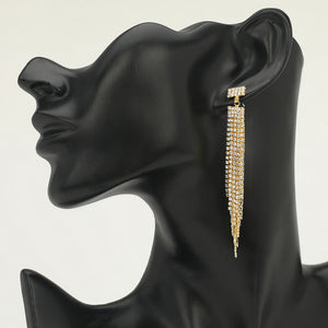 Long clear rhinestone tassel fringe earrings on gold displayed on black mannequin bust