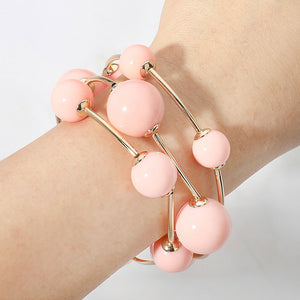 Peach beaded stackable stretch bracelet set on gold on a model's writst