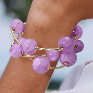 Close-up of a lavender chunky ball 3-piece stretch bracelet set on a model’s wrist with a softly blurred background.
