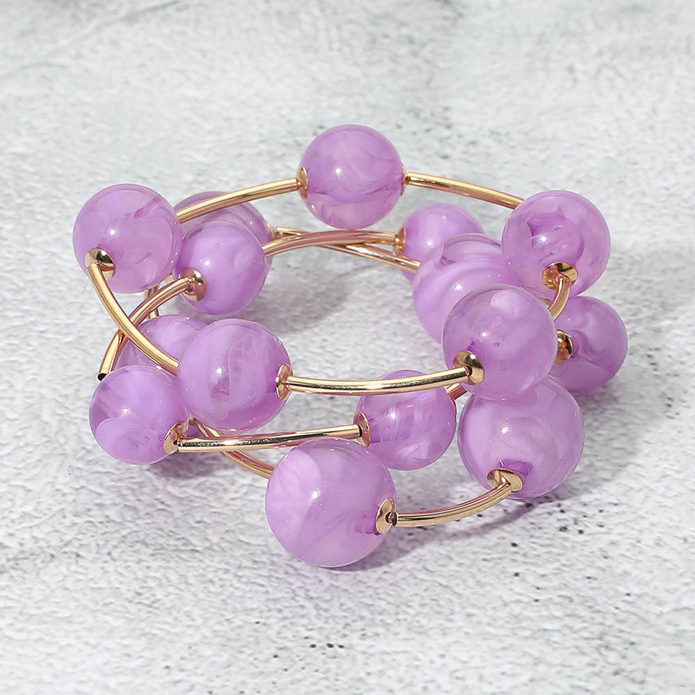 Lavender chunky ball 3-piece stretch bracelet set on gold displayed on a light textured background.