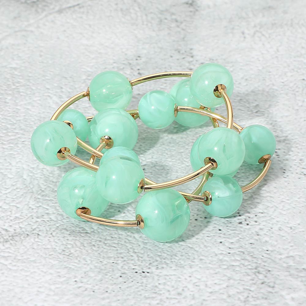 Mint chunky ball 3-piece stretch bracelet set on gold displayed on a light textured background.