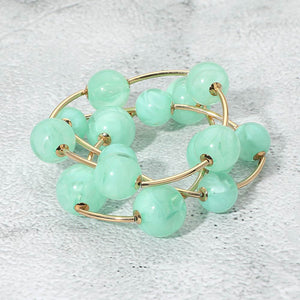 Mint chunky ball 3-piece stretch bracelet set on gold displayed on a light textured background.