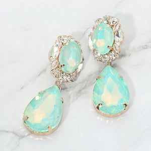 Mint oval and teardrop dangle earrings on gold on a white marble background