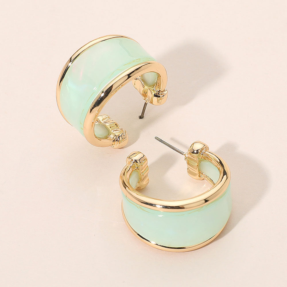 Mint marbled resin half hoop earrings with wide chunky statement design trimmed in gold for fun fashion and everyday wear on a light beige background