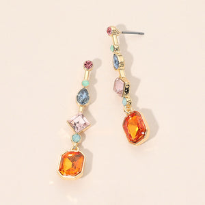 A pair of gold geometric drop earrings with multiple colorful gemstones, including orange, pink, blue, and light green stones, displayed on a light beige background.