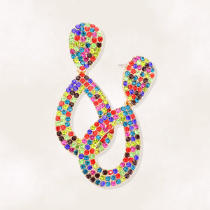 Multi-color rhinestone pavé cut out teardrop pageant and formal earrings on a beige background