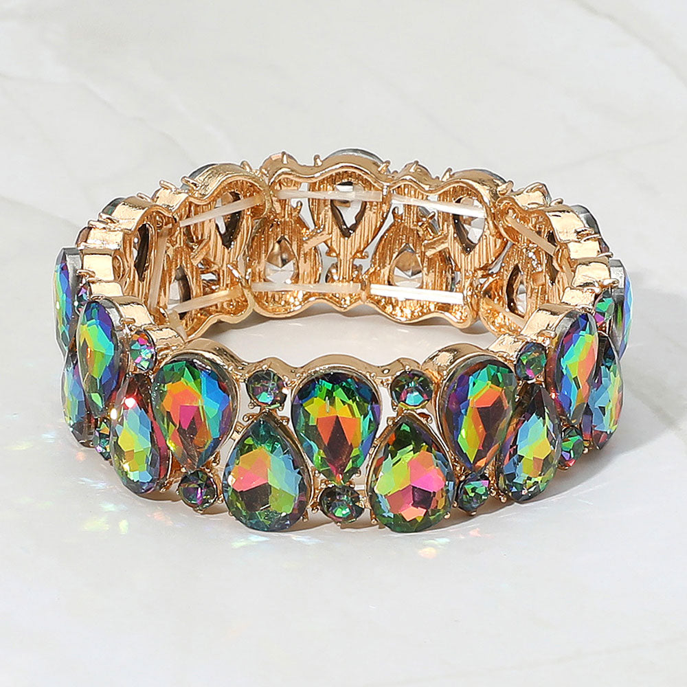 Multi-color teardrop and round stone cluster stretch bracelet on gold on white marble background