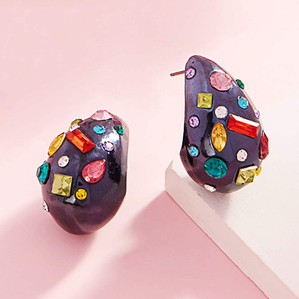 Multi color stone teardrop earrings on black with vibrant mixed crystals, 1.25 inch drop earrings on a pink background
