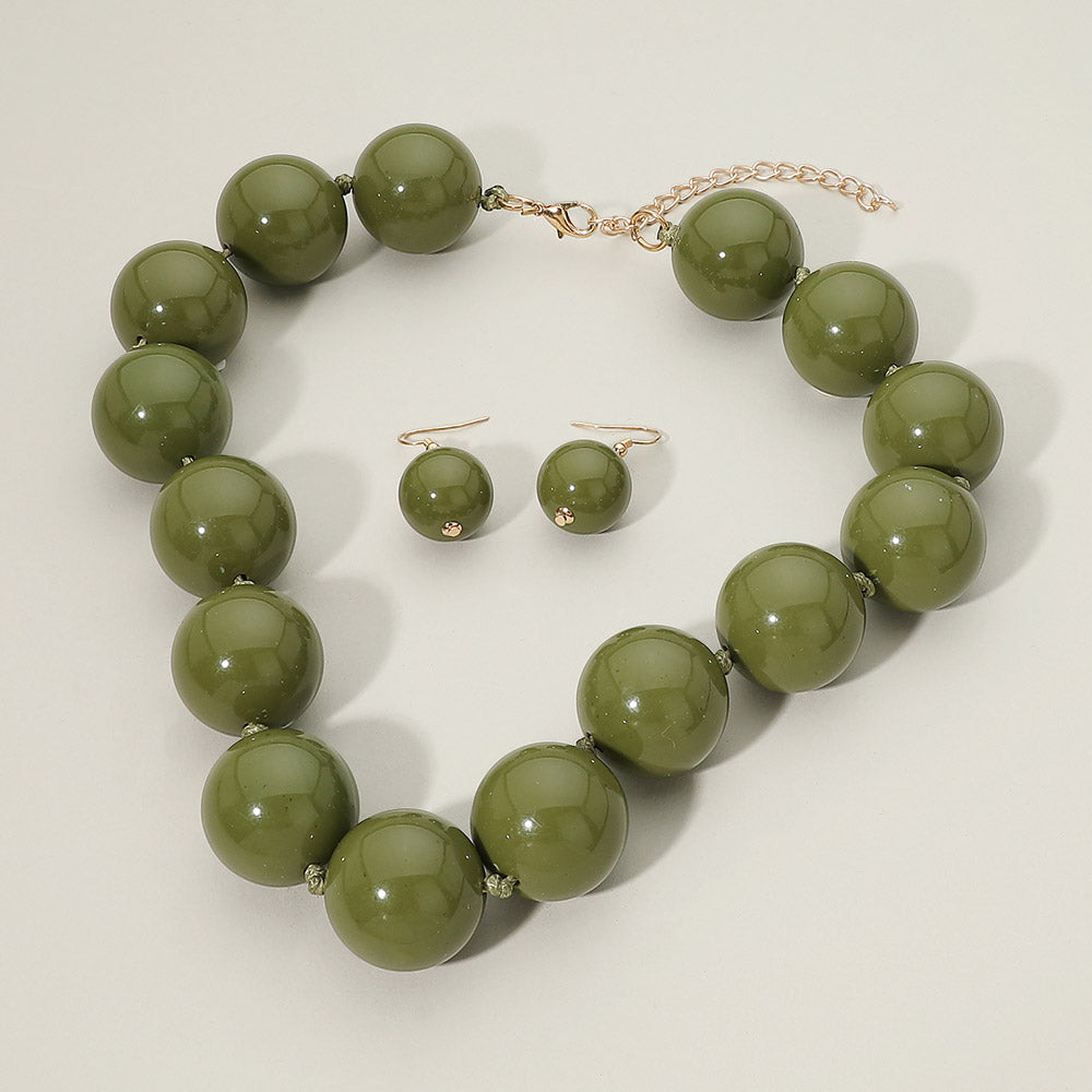 Olive Green chunky ball beaded statement necklace set with oversized round beads and matching drop earrings, displayed on a light cream background.