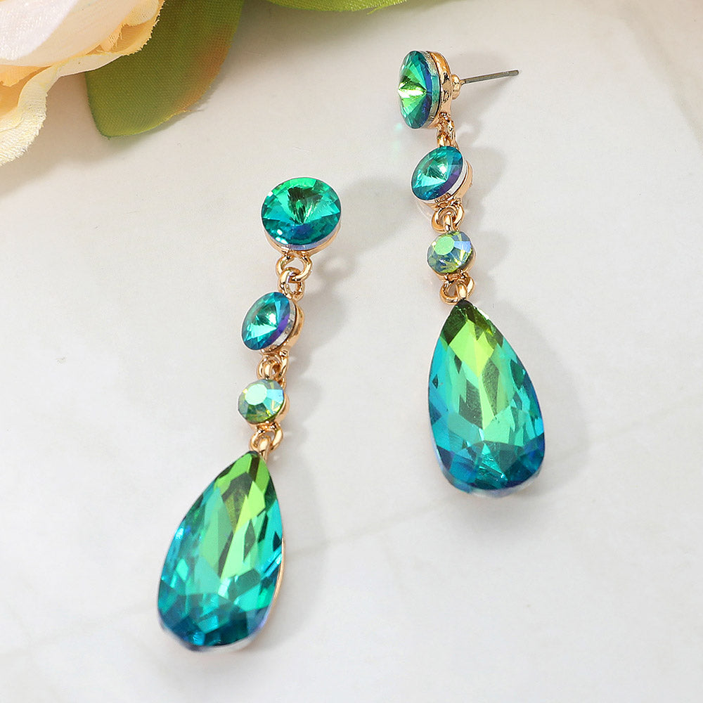 Olive green rhinestone multi stone dangle earrings with teardrop crystal on a white background