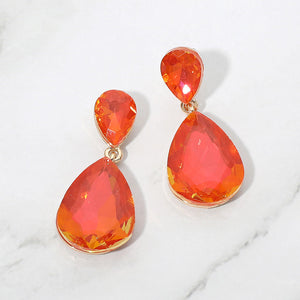 Orange opal crystal double teardrop dangle earrings on gold displayed on a white marble background.