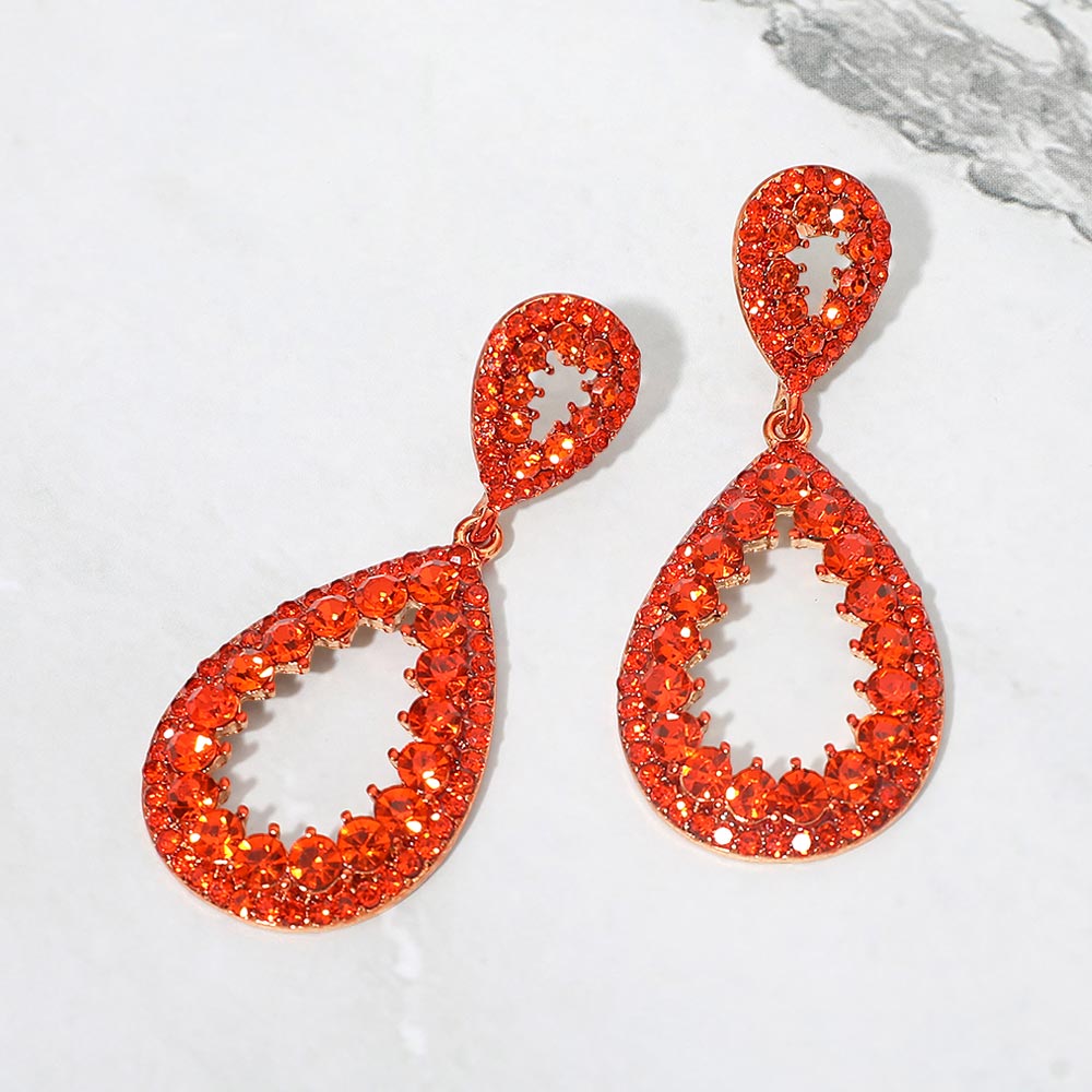 Orange pave open teardrop earrings on gold displayed on white marble background