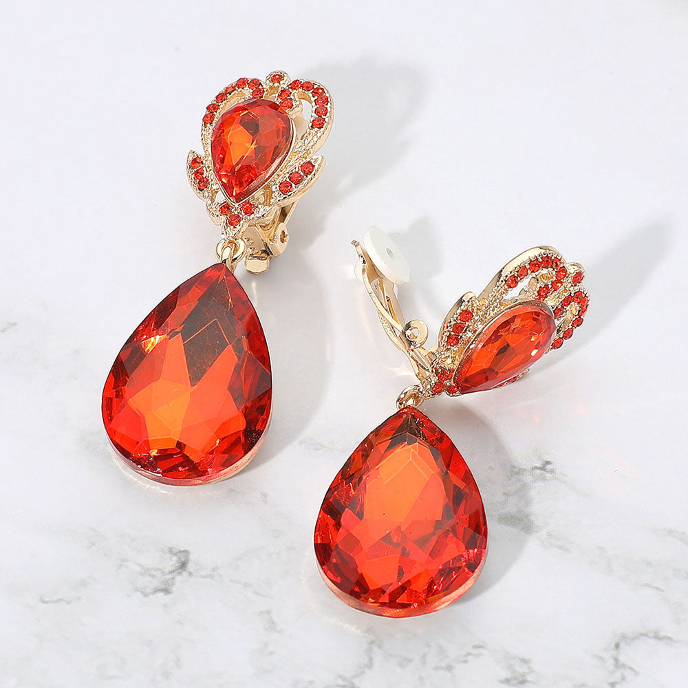 Orange faceted teardrop stone clip-on earrings on gold. Top stone is elegantly surrounded by an array of rhinestones in a flower like setting. 
