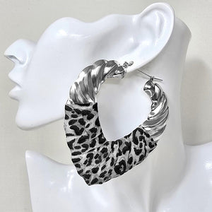 Large silver-tone hoop earrings with a black and white leopard print fabric accent, displayed on a white mannequin head.