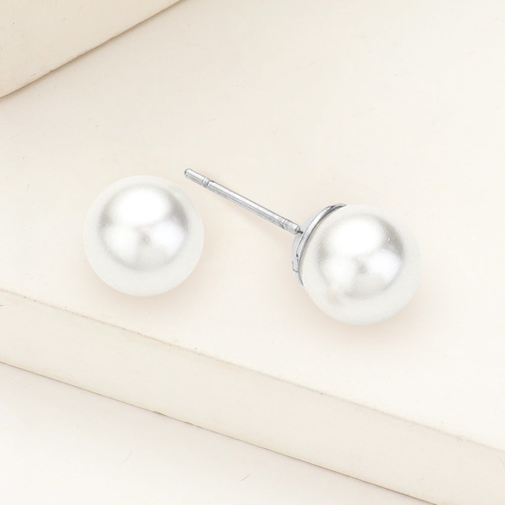 White pearl stud earrings 0.3 inch 8mm on silver on beige background