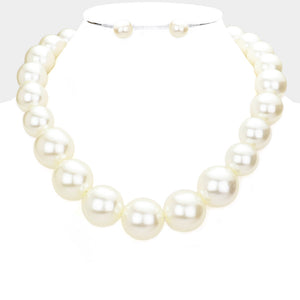 Cream oversized pearl statement necklace set with large round pearl beads and matching earrings, displayed on a white mannequin bust.