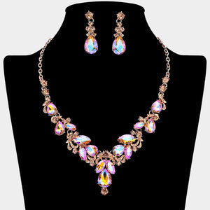 Peach AB marquise cluster necklace with teardrop accents and matching earrings on a black mannequin bust for prom or pageant wear