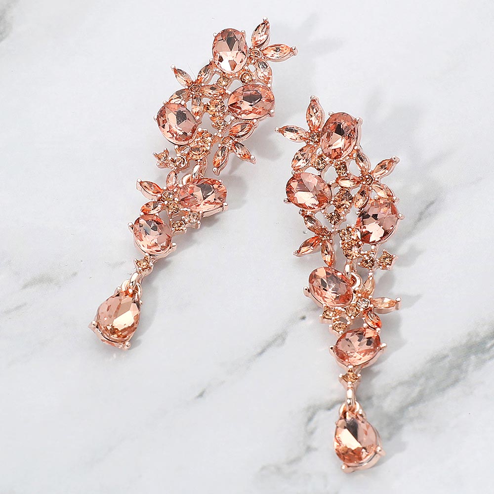 Peach floral crystal drop earrings on rose gold with marquise stones for weddings or everyday elegance on a marble background
