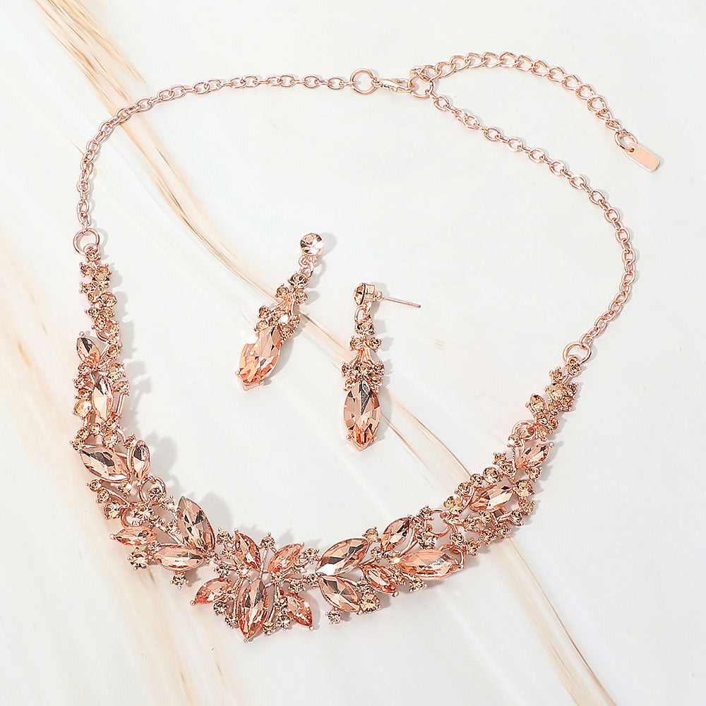 Peach marquise stone cluster prom and evening necklace set on rose gold on white marble background