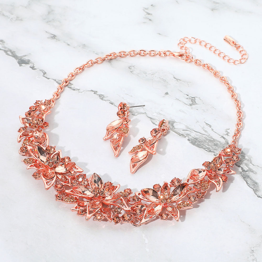 Peach and rose gold collar-bib necklace set with earrings for homecoming, weddings, or pageants on a grey and white granite background
