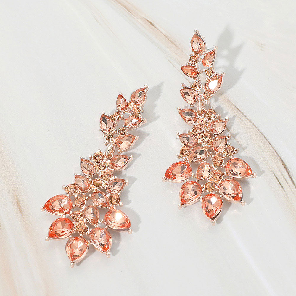 Peach teardrop cluster drop earrings on rose gold with faceted stones on white marble background