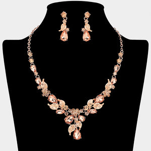 Blush crystal teardrop leaf necklace and earring set on rose gold for formal events and pageants on a black mannequin bust on a white background.