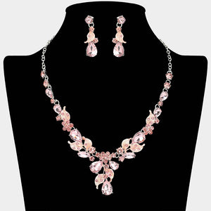 Pink teardrop leaf necklace set on silver with matching earrings for prom and evening wear on a black mannequin bust on a white background.
