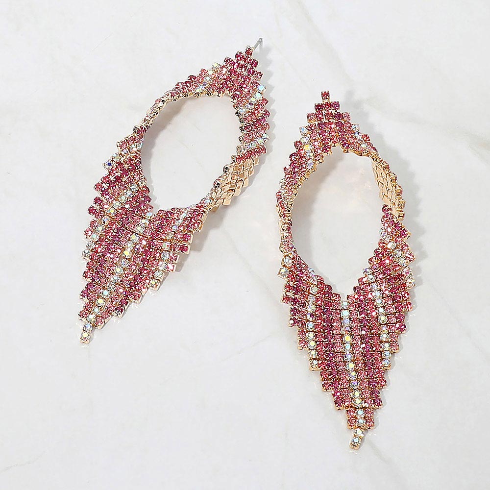 Pink crystal abstract layered statement earrings on gold displayed on a white background.