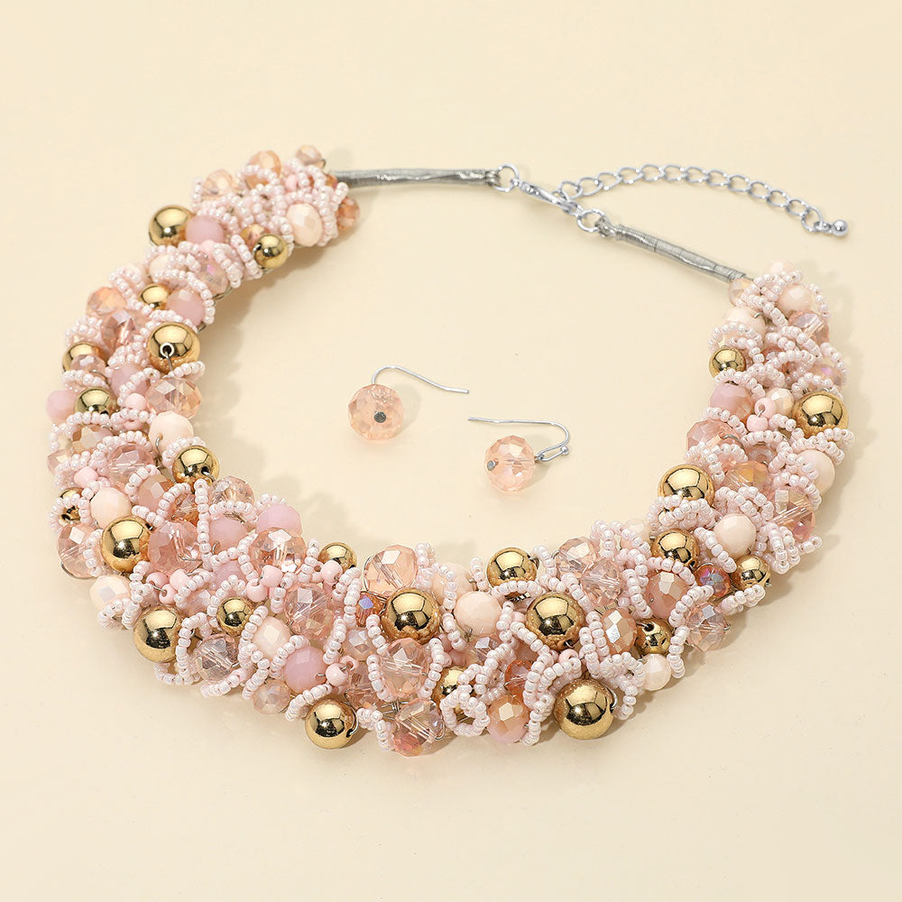 Pink faceted beaded collar necklace set with matching earrings in a fun fashion statement style on a beige background